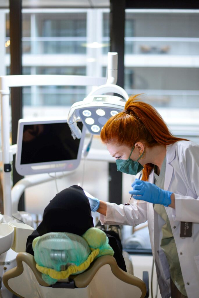 A dentist in a modern clinic performing a checkup on a patient, showcasing dental technology.